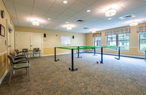 A spacious, well-lit conference room with tables and chairs arranged for a meeting.
