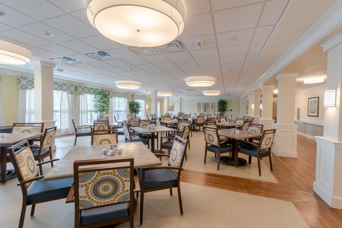 A spacious and elegantly decorated dining room with multiple tables and chairs.