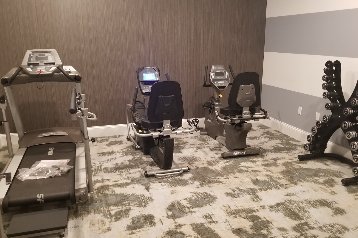 A gym room with exercise bikes arranged neatly on a patterned carpet.