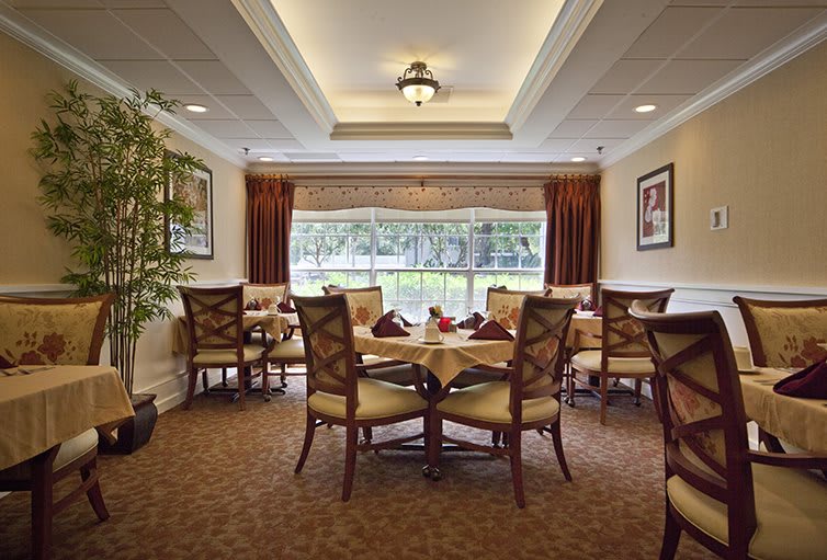 Elegant dining area with beautifully set tables and large windows.