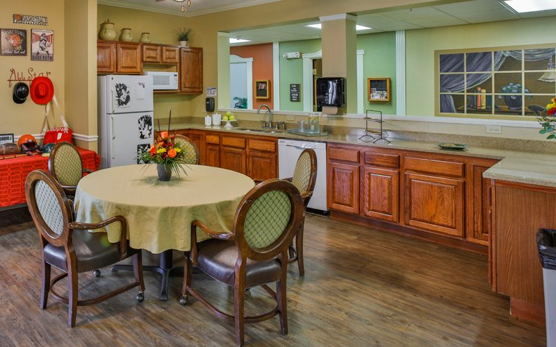 A cozy kitchen and dining area with wooden cabinets and a round table.