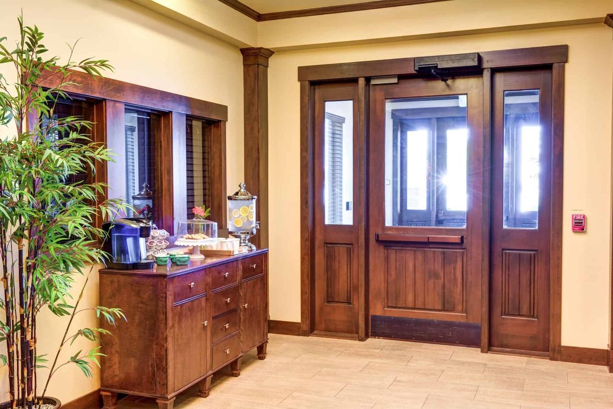 A cozy waiting area with a coffee station and wooden doors.