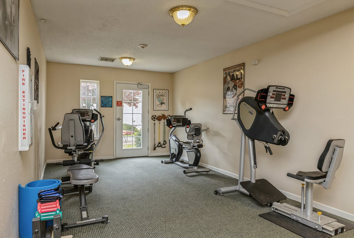 A small gym with various exercise equipment, including treadmills and stationary bikes.