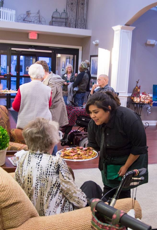 A community event with people engaging in conversation indoors.