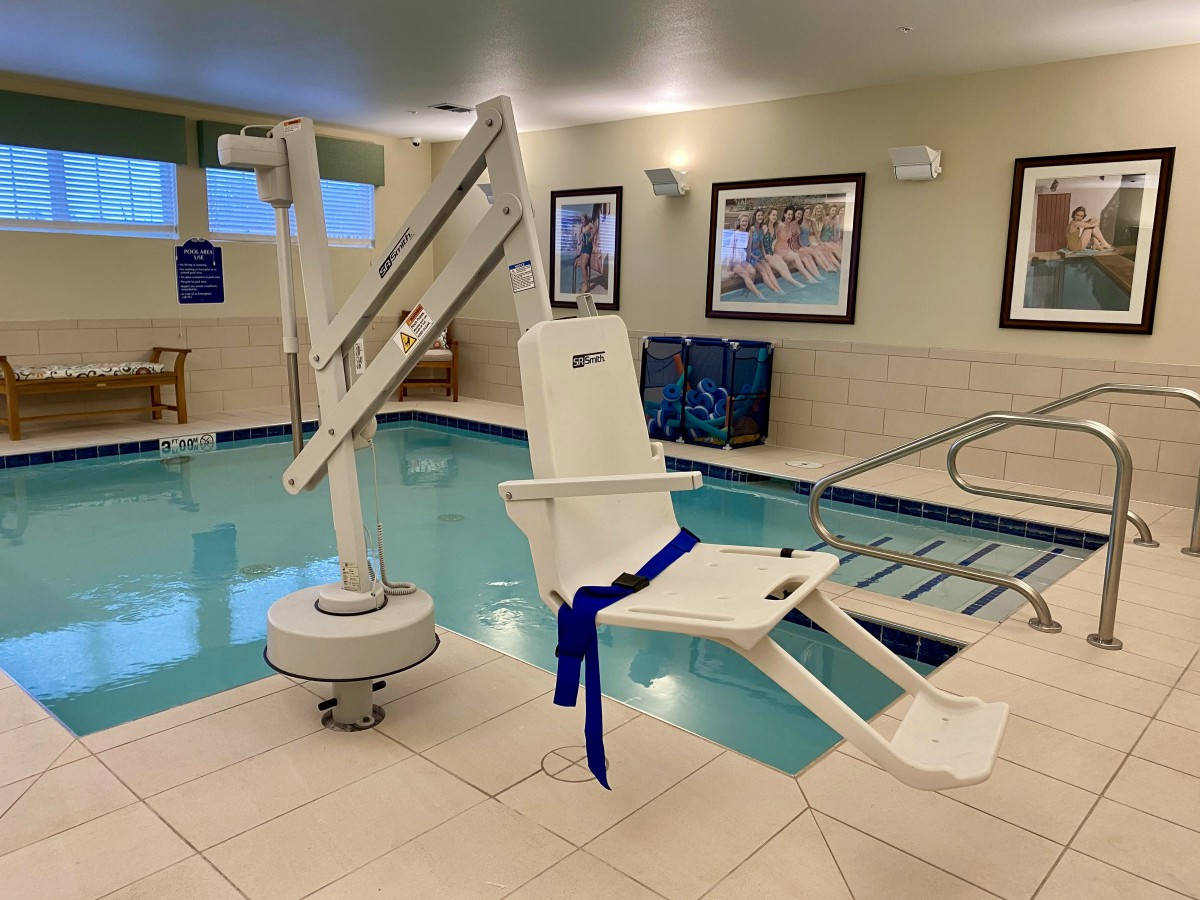 An indoor hotel pool equipped with an accessibility lift for disabled swimmers.
