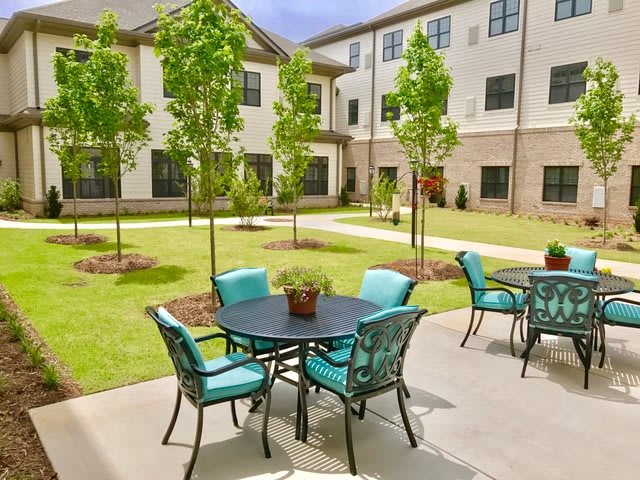A landscaped courtyard with outdoor seating and a modern apartment building backdrop.