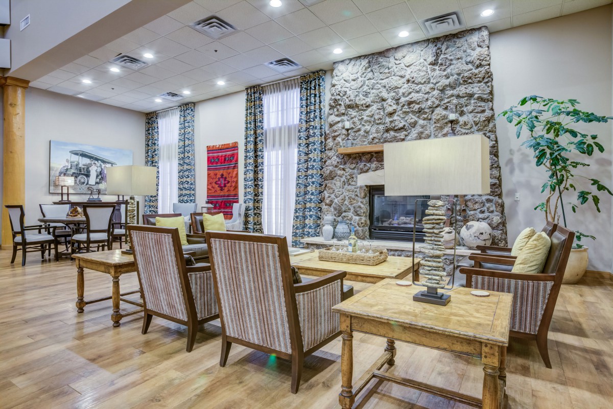 A modern living room featuring a stone fireplace and comfortable seating area.