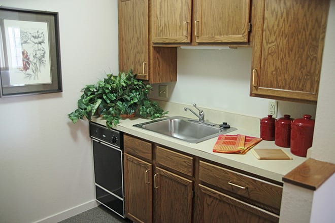 A small kitchen area with wooden cabinets, a sink, and countertop appliances.