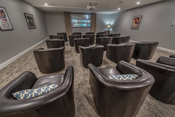 A cozy home theater with comfortable seating and a projector screen.