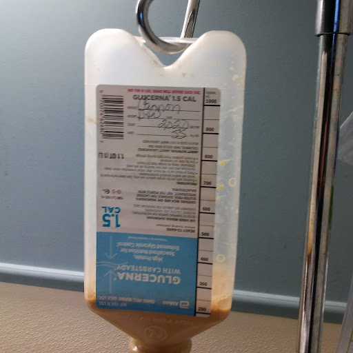 An IV bag filled with liquid medication hanging on a stand.