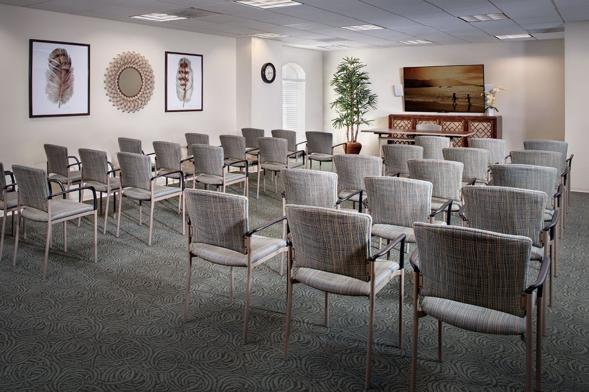 An empty conference room with rows of chairs arranged for a meeting or presentation.
