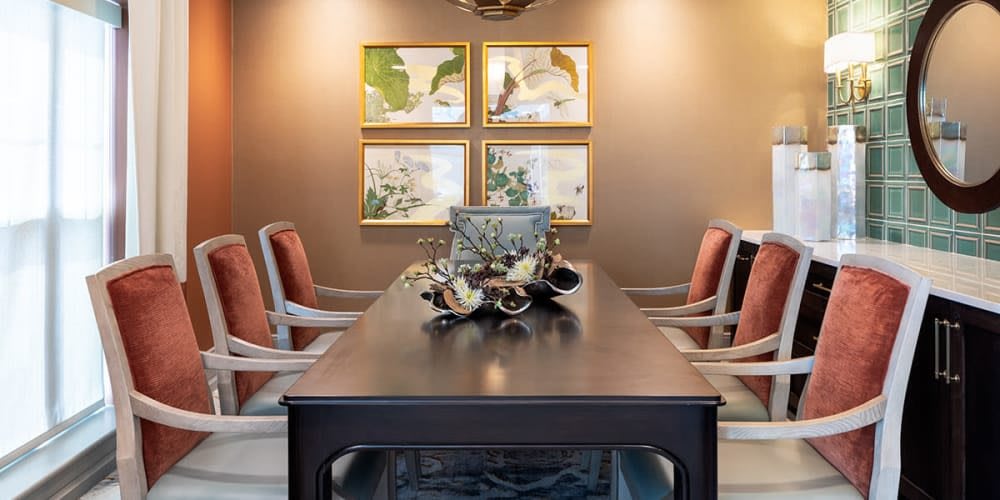 A well-decorated dining room featuring a modern table and chairs, along with elegant artwork on the wall.