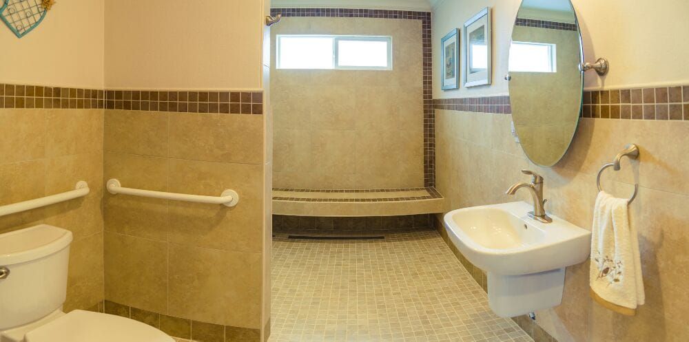 A spacious, accessible bathroom with a tiled walk-in shower and grab bars.
