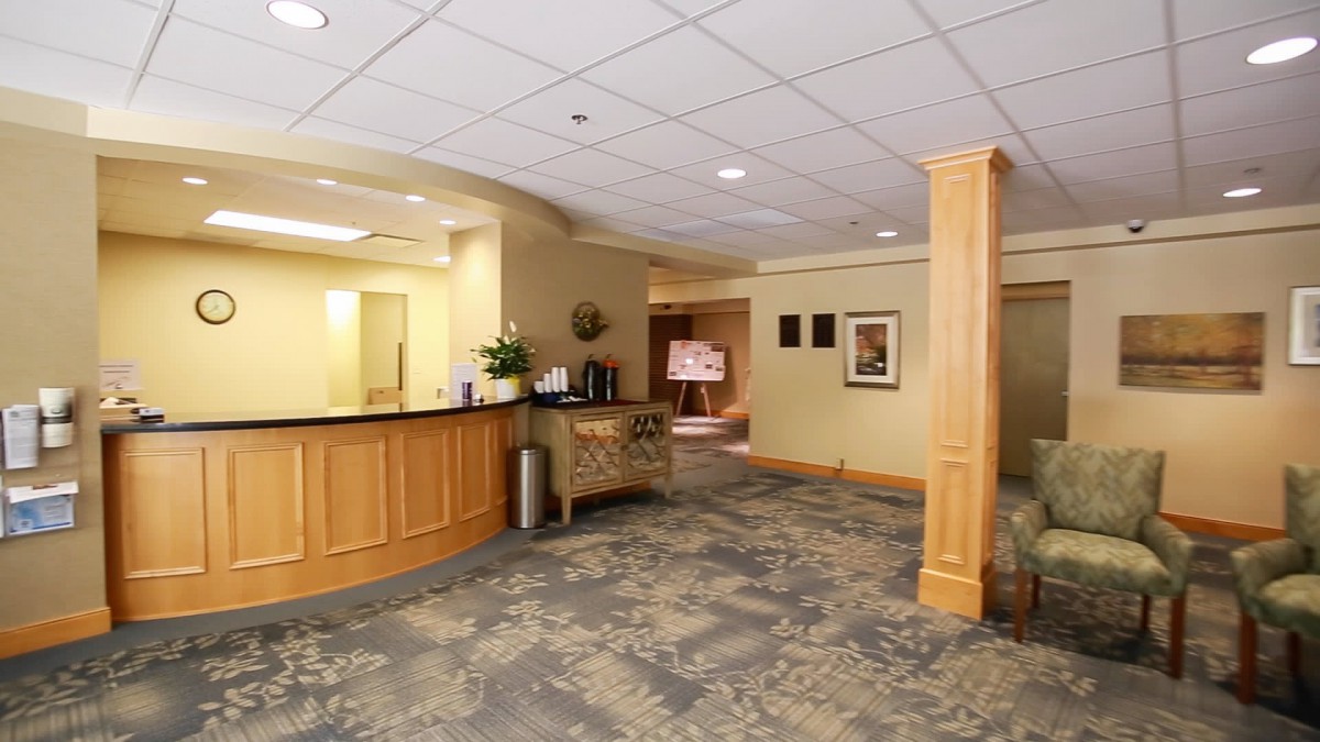 A spacious hotel lobby with a reception desk and cozy waiting area.