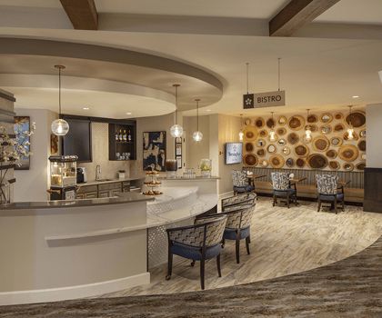 A modern lobby area featuring a stylish bar with comfortable seating and elegant lighting.