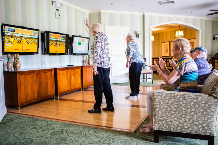 Seniors enjoying a video game session together indoors.