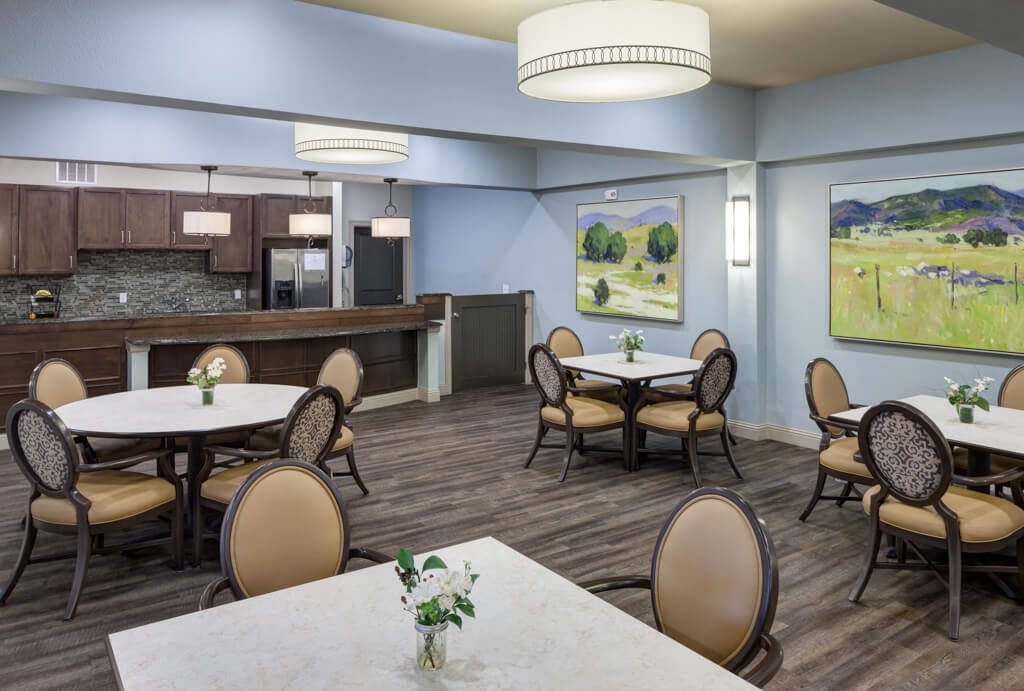 A modern dining area with elegantly arranged tables and chairs, featuring stylish artwork on the walls.