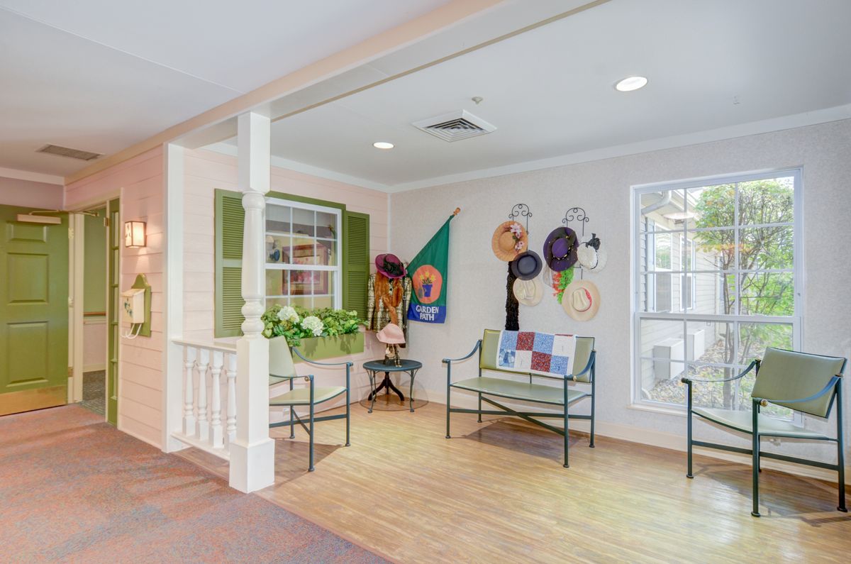 A cozy lobby area with seating and colorful hat decorations on the wall.