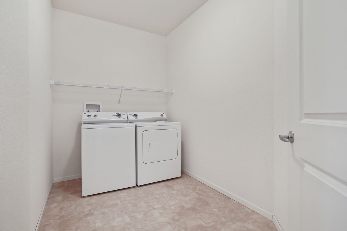 A spacious laundry room with a washer and dryer.