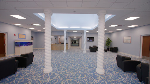 A spacious and modern lobby featuring twisted columns and a blue patterned carpet.