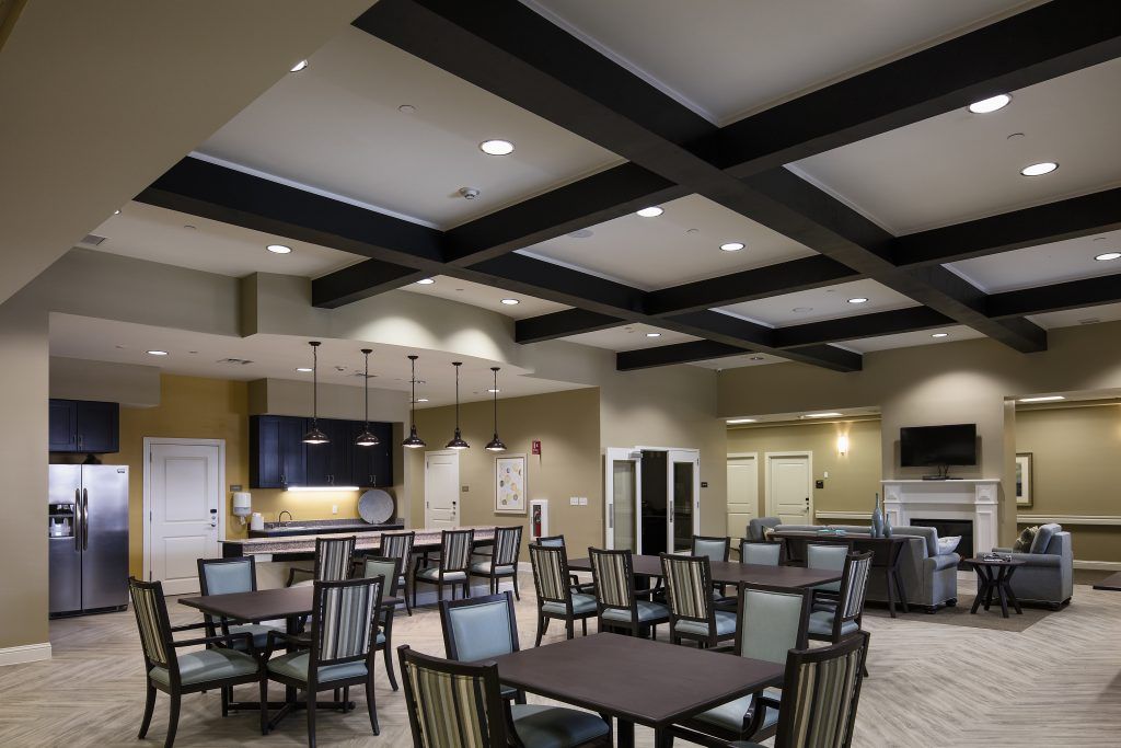 A modern dining area with neatly arranged tables and chairs, featuring stylish lighting.