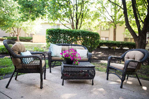 A cozy outdoor seating area surrounded by lush greenery, perfect for relaxation.