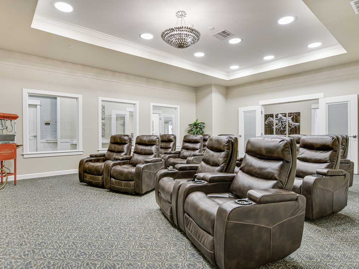 A luxurious home theater room with multiple recliner chairs arranged for optimal viewing.