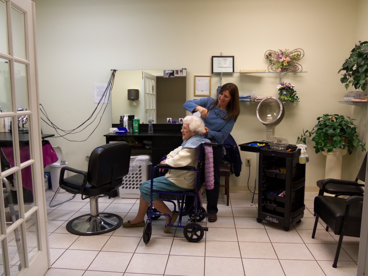 A hairstylist working on a client's hair in a salon setting.