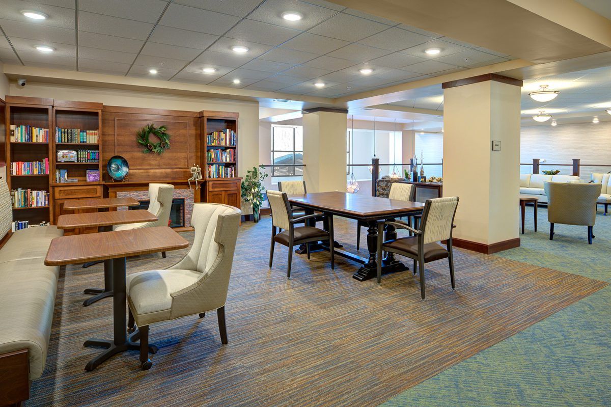 A modern lounge area with tables and chairs, featuring warm lighting and stylish decor.