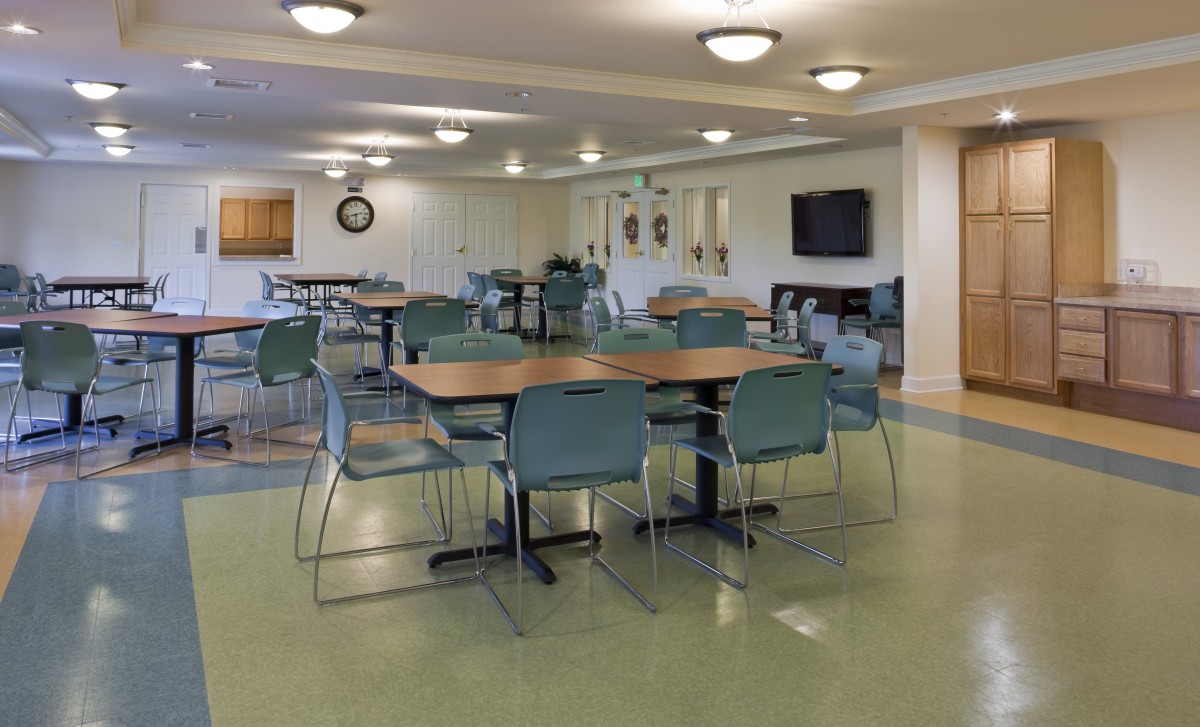 An empty dining area with tables and chairs, well-lit and spacious.