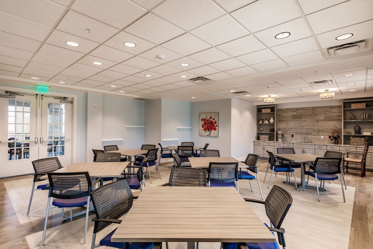 A modern conference room with several tables and chairs arranged for meetings.