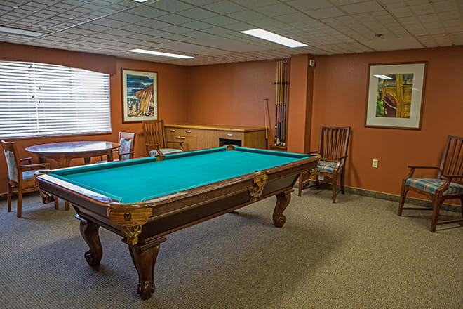 A cozy game room featuring a classic pool table with decor on the walls.