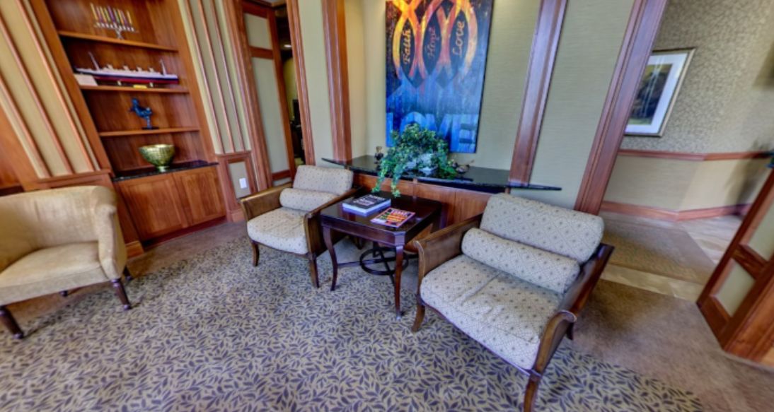 A cozy waiting area with two chairs, a small table, and decorative artwork.