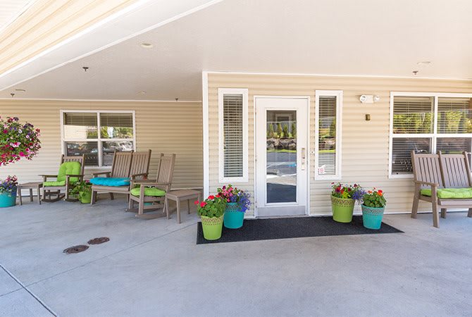 A welcoming entrance with potted plants and outdoor seating.