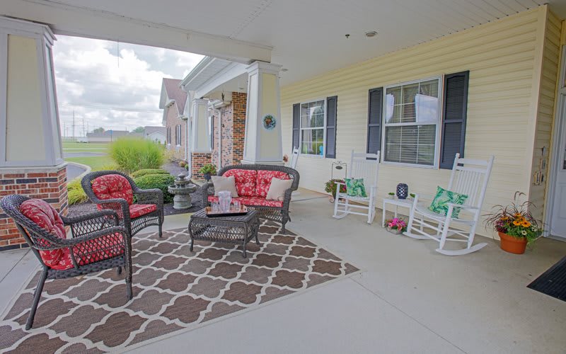 A cozy front porch with comfortable seating and colorful cushions.