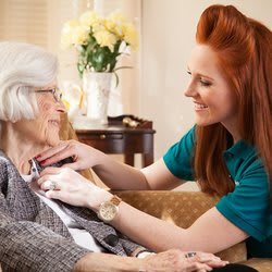 A caregiver assisting an elderly woman at home.