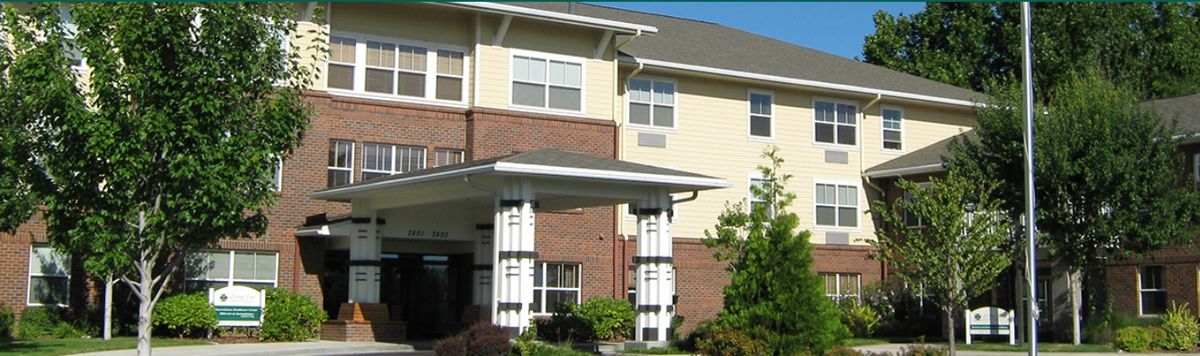 A view of a residential building entrance with brick and siding exterior.