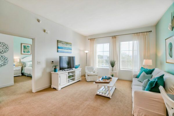 A bright and modern living room with a television, comfortable seating, and elegant decor.