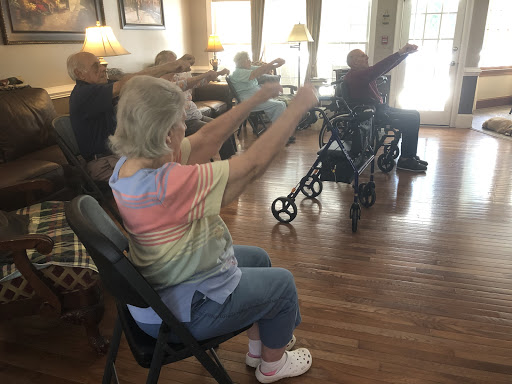 Elderly participants engage in a group exercise session, promoting health and social interaction.