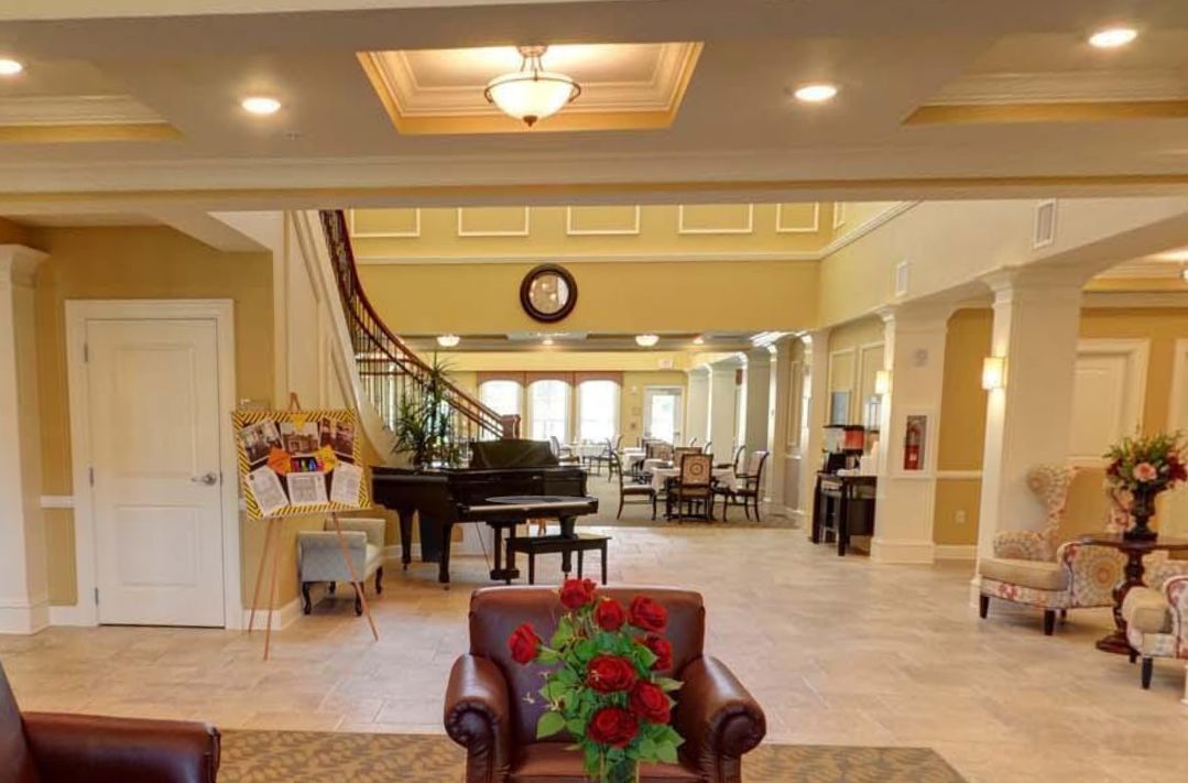 A bright and spacious lobby featuring a grand piano, comfortable seating, and elegant decor.