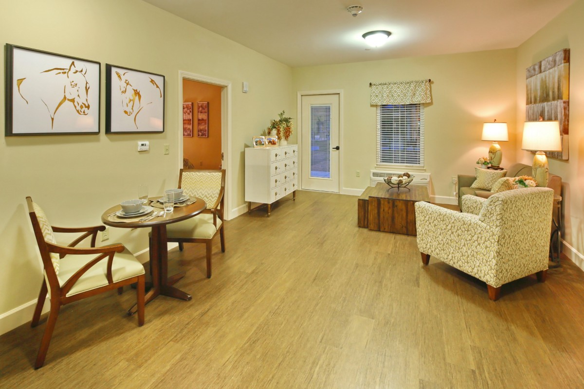 A cozy living room with a dining area, featuring stylish furniture and warm lighting.
