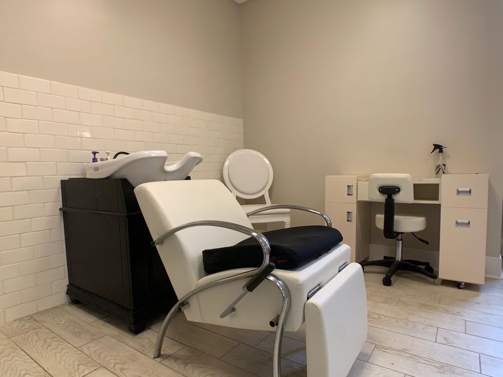 A modern salon interior featuring a hair washing station and seating area.