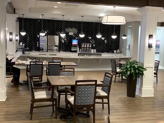 A modern, empty cafe interior with tables and chairs.