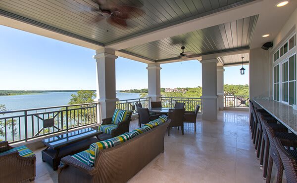 A spacious balcony with comfortable seating overlooking a picturesque lake.