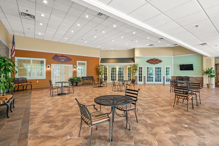 A spacious community center dining area with multiple tables and chairs arranged for social gatherings.