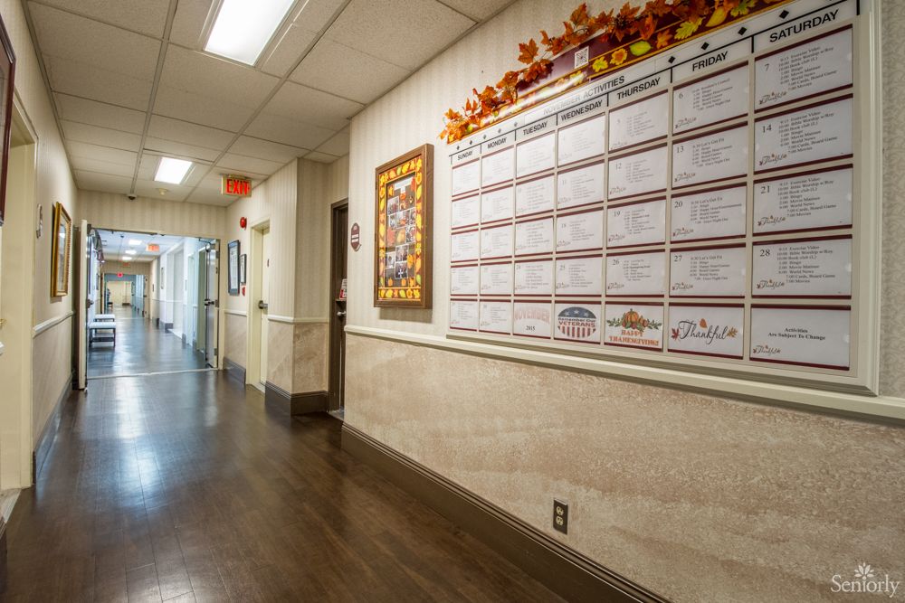 A building hallway with a large calendar on the wall decorated with autumn-themed accents.