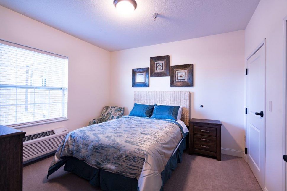 A cozy bedroom with a neatly made bed and decorative artwork on the wall.