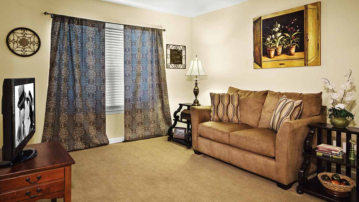A cozy living room with a brown sofa and decorative curtains.