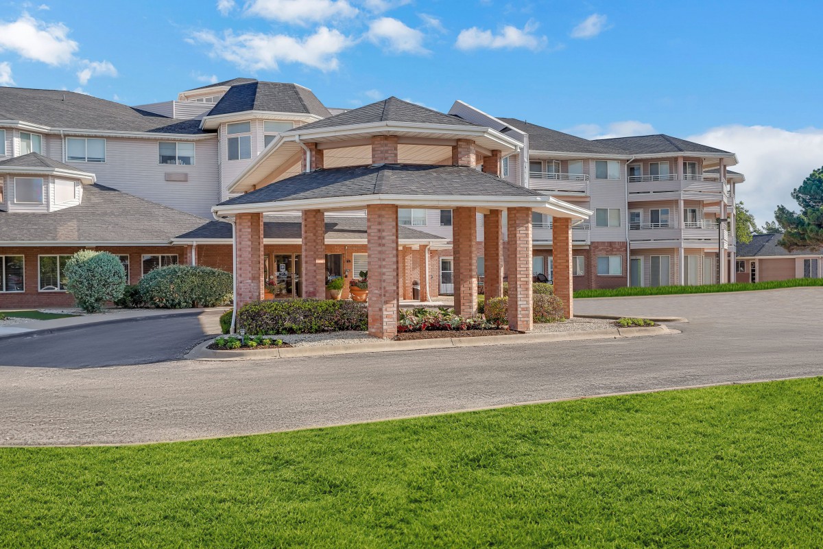 A modern residential building with a covered entrance and well-maintained landscaping.