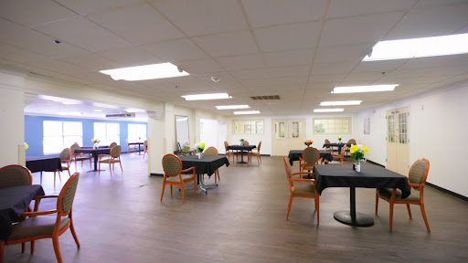 A spacious dining area featuring tables and chairs, designed for comfortable gatherings.